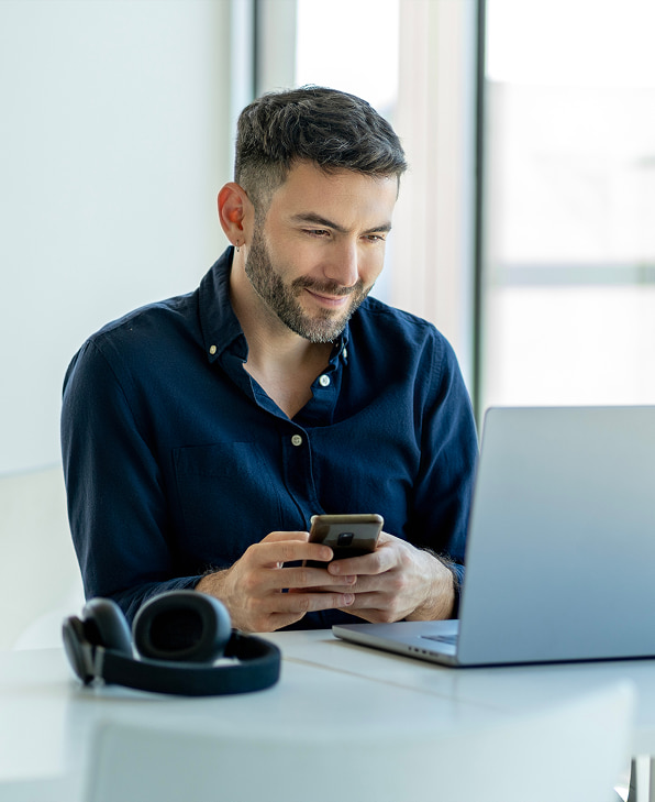 un homme sourit en regardant son téléphone