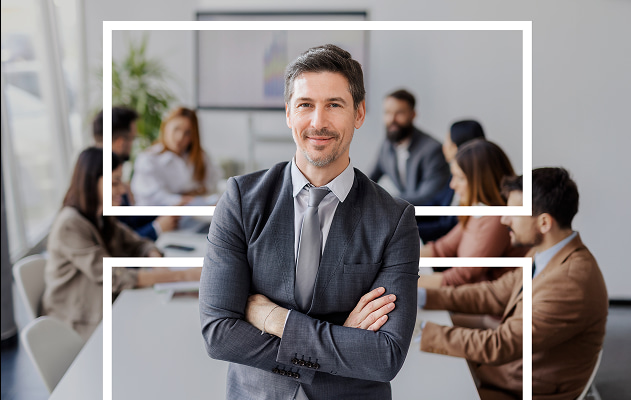 Un homme en costume regarde droit devant lui dans un cadre professionnel